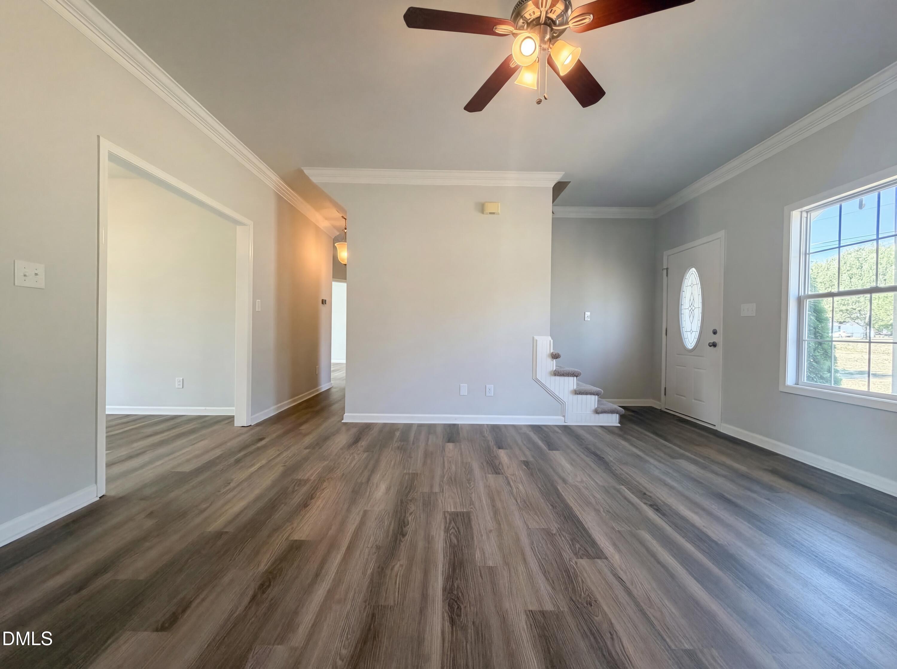 1071 Darius Pearce Road Youngsville, NC 27596 - Photo 4 of 22 an empty room with wooden floor fan and windows