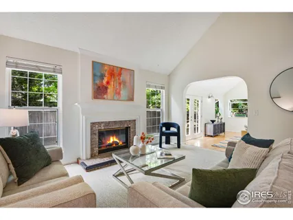 a living room with furniture a fireplace and a large window