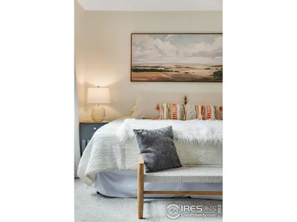 a bedroom with a bed and painting on the wall