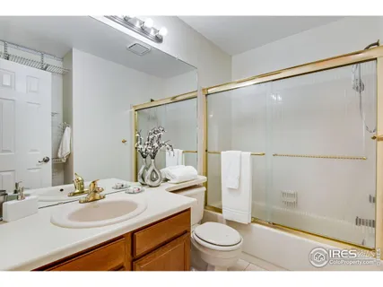 a bathroom with a granite countertop toilet a sink and mirror