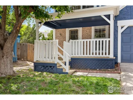 a view of a house with a small yard and wooden fence