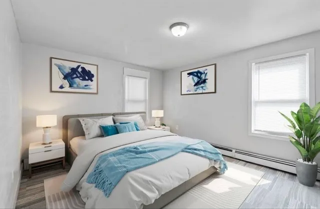 a bedroom with a large bed and a potted plant