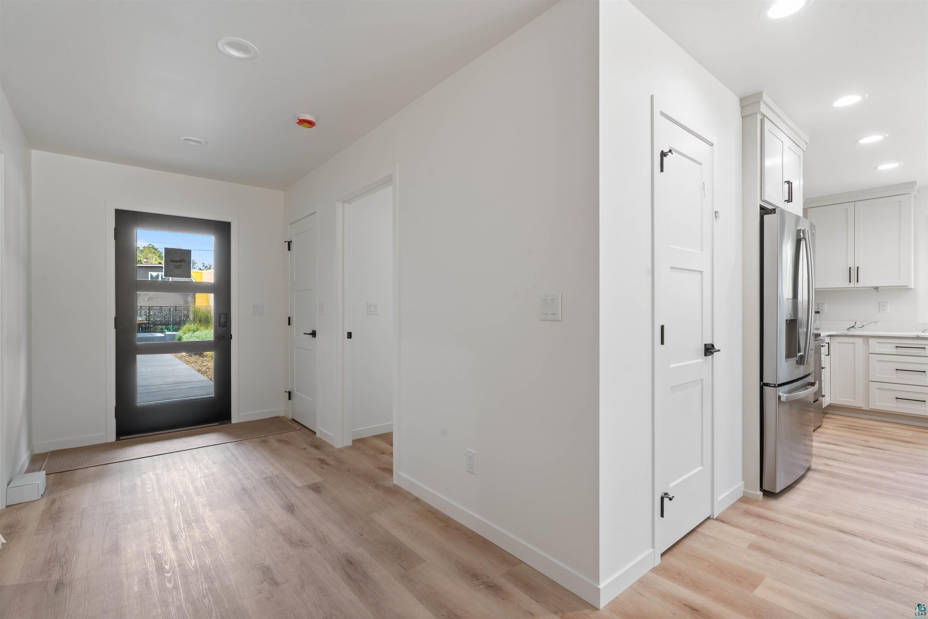 1386 Stephen Road Cloquet, MN 55720 - Photo 22 of 25 Entryway featuring wood-finish flooring, a contemporary glass-paneled door, recessed lighting, and crisp white walls