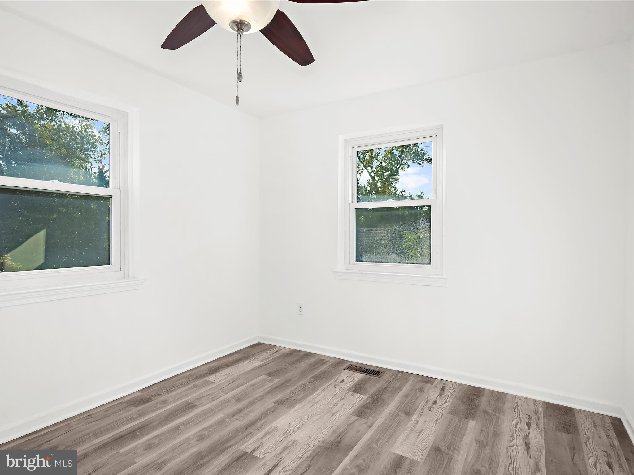 400 Dale Avenue Baltimore, MD 21206 - Photo 11 of 27 an empty room with wooden floor chandelier fan and windows