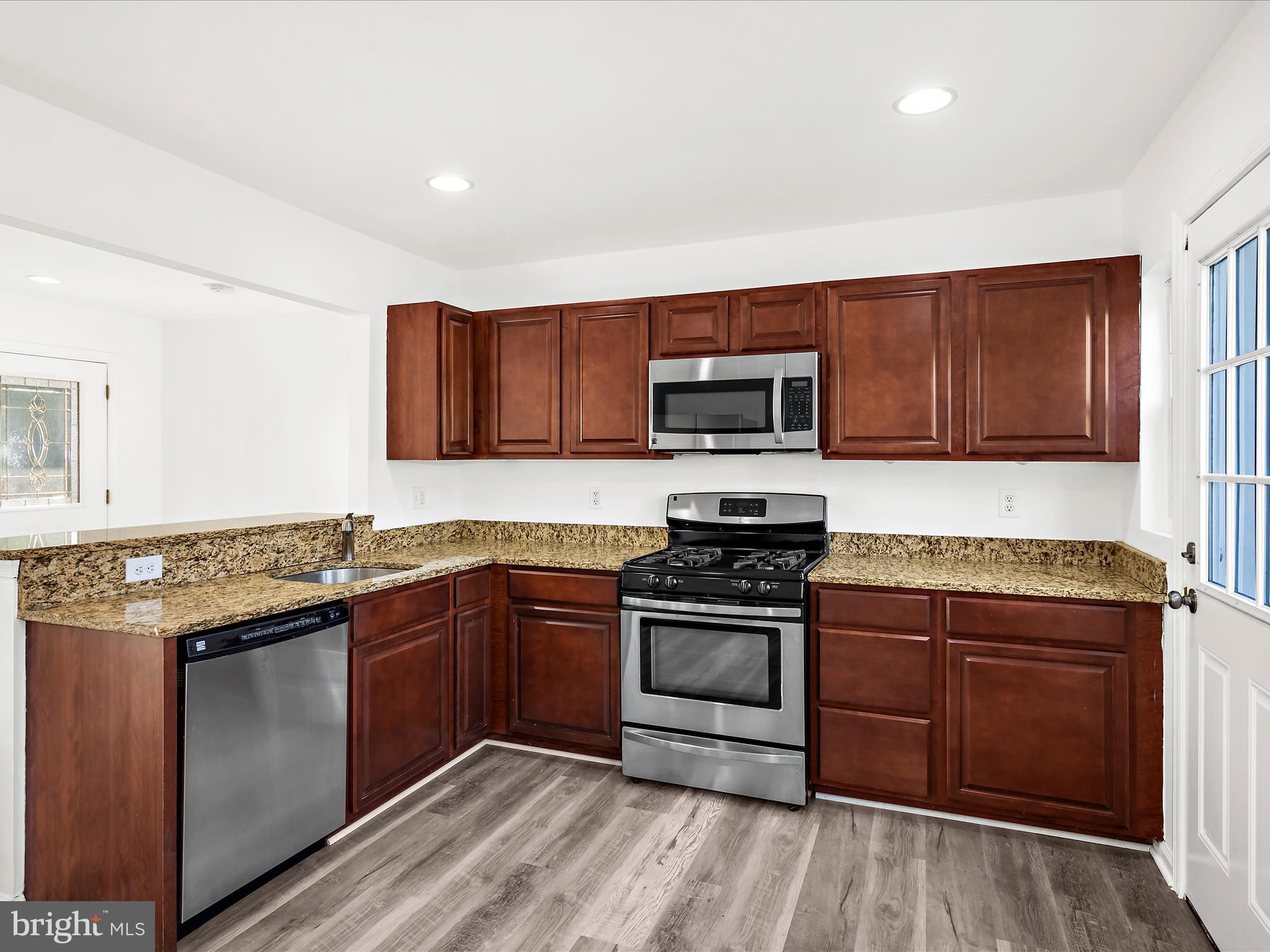 400 Dale Avenue Baltimore, MD 21206 - Photo 8 of 27 a kitchen with stainless steel appliances granite countertop wooden cabinets stove top oven and sink
