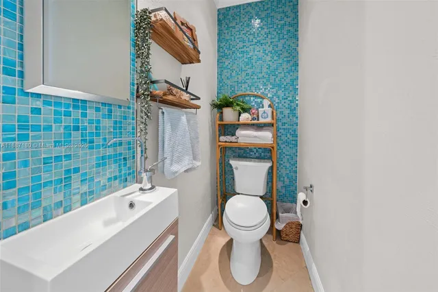 a bathroom with a toilet sink and mirror
