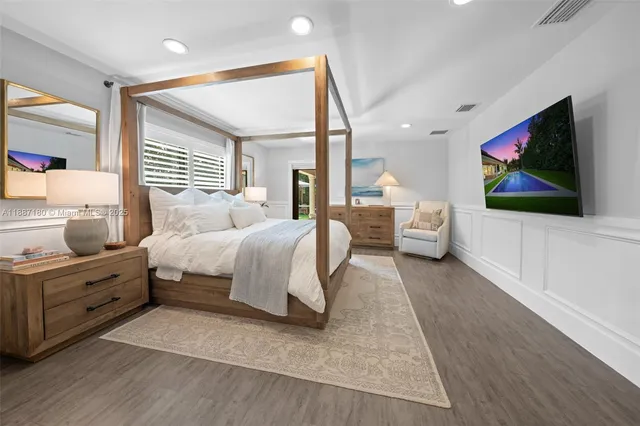 a bedroom with a large bed and a flat screen tv