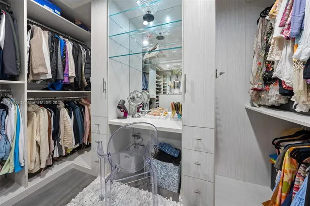 a view of walk in closet with clothes and shoes