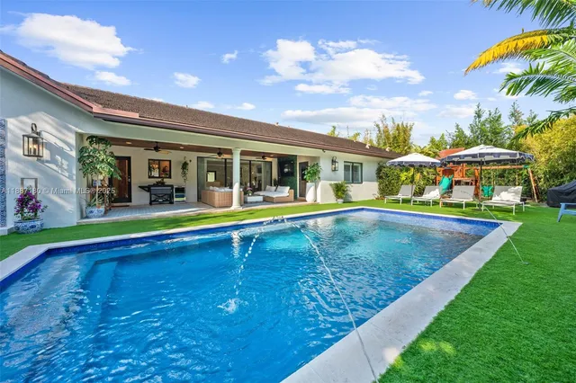 a view of a house with a swimming pool and sitting area
