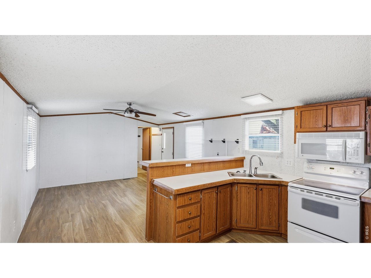 256 Navajo Road Weldona, CO 80653 - Photo 11 of 27 a kitchen with a stove a sink and a refrigerator