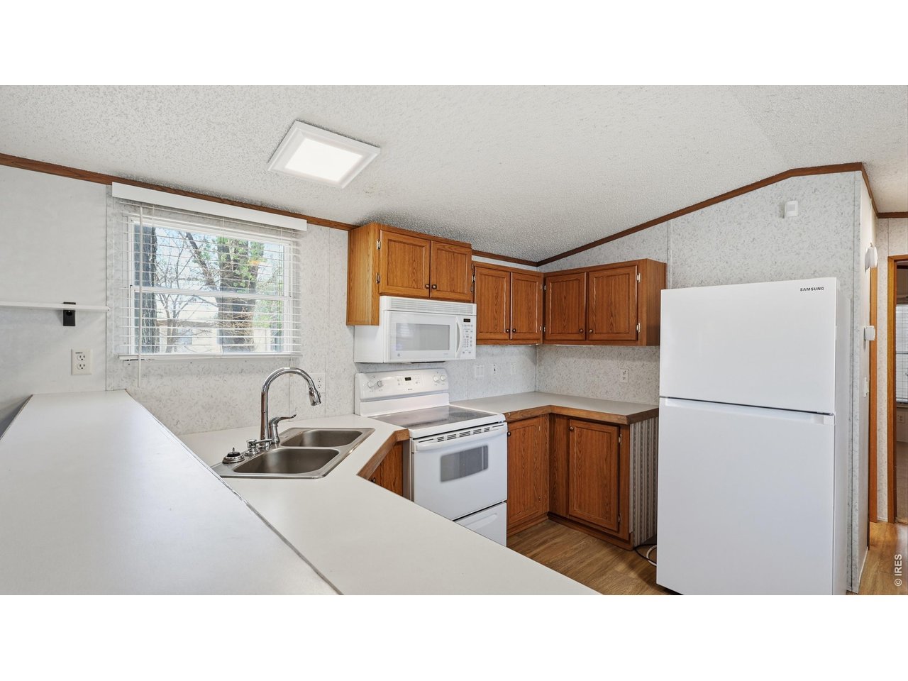 256 Navajo Road Weldona, CO 80653 - Photo 8 of 27 a kitchen with a refrigerator a sink and a cabinets