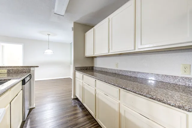 a kitchen with granite countertop a sink and cabinets