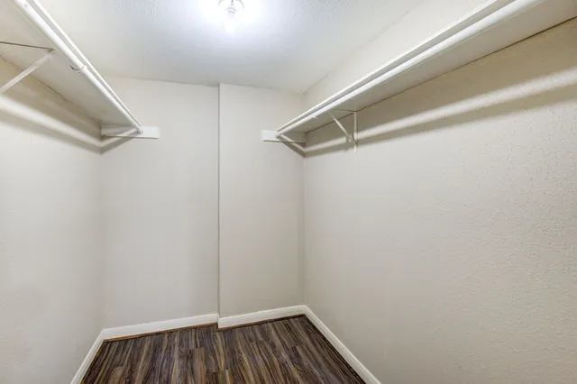 a view of walk in closet with empty racks