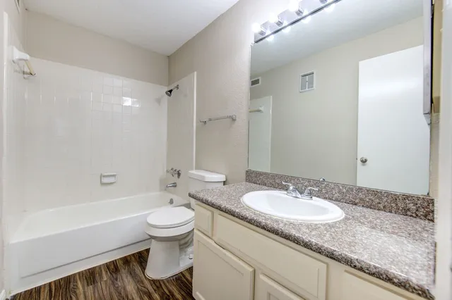a bathroom with a granite countertop sink toilet and shower