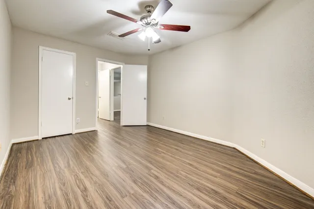 a view of an empty room with wooden floor