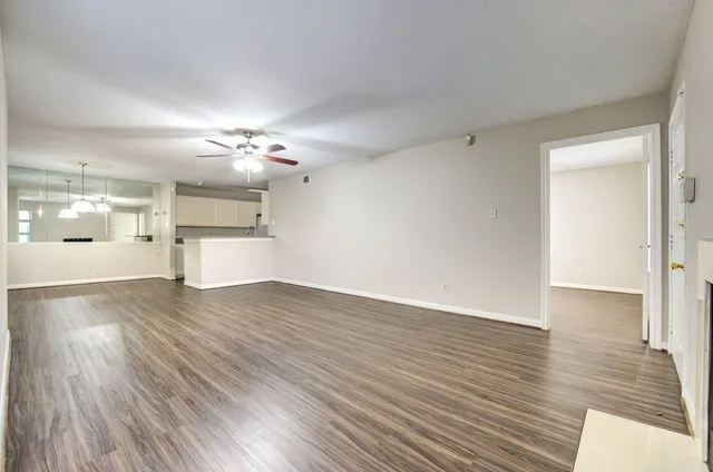 a view of a big room with wooden floor and a kitchen