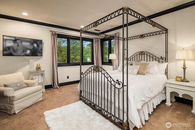 a bedroom with bed and a large window