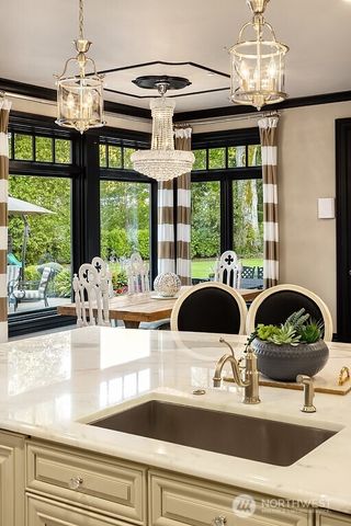 a kitchen with a stove a sink and a dining table with garden view