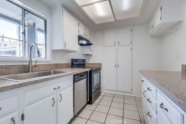 a kitchen with granite countertop white cabinets and white appliances
