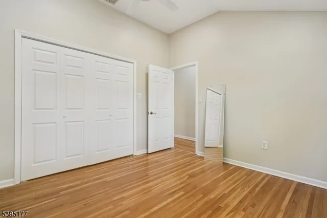 an empty room with wooden floor and closet area