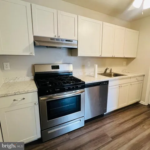 a kitchen with granite countertop white cabinets and white appliances
