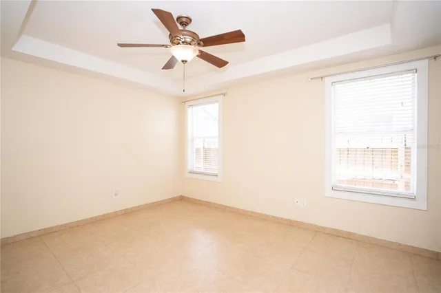 an empty room with a window and a fan