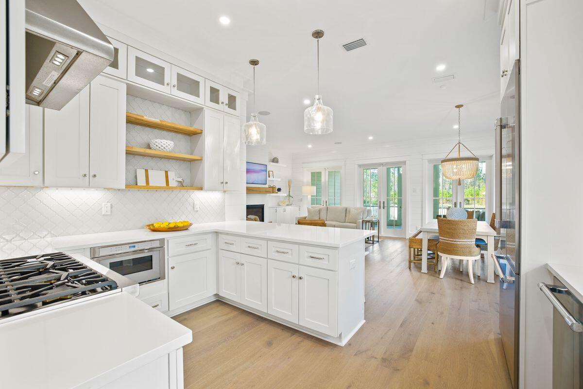 41 Seastone Ct Inlet Beach Inlet Beach, FL 32461 - Photo 14 of 52 a kitchen with a white cabinets and chairs