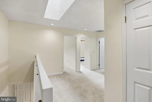 a spacious bedroom with a large bed and a chandelier