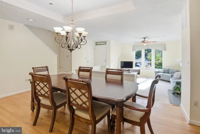 a view of a dining room with furniture a chandelier and wooden floor