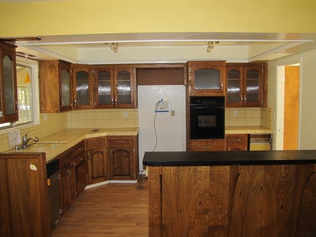 19071 West Allan Volcano, CA 95689 - Photo 41 of 42 Kitchen with glass insert cabinets, dark wood-style floors, tasteful backsplash, and black oven