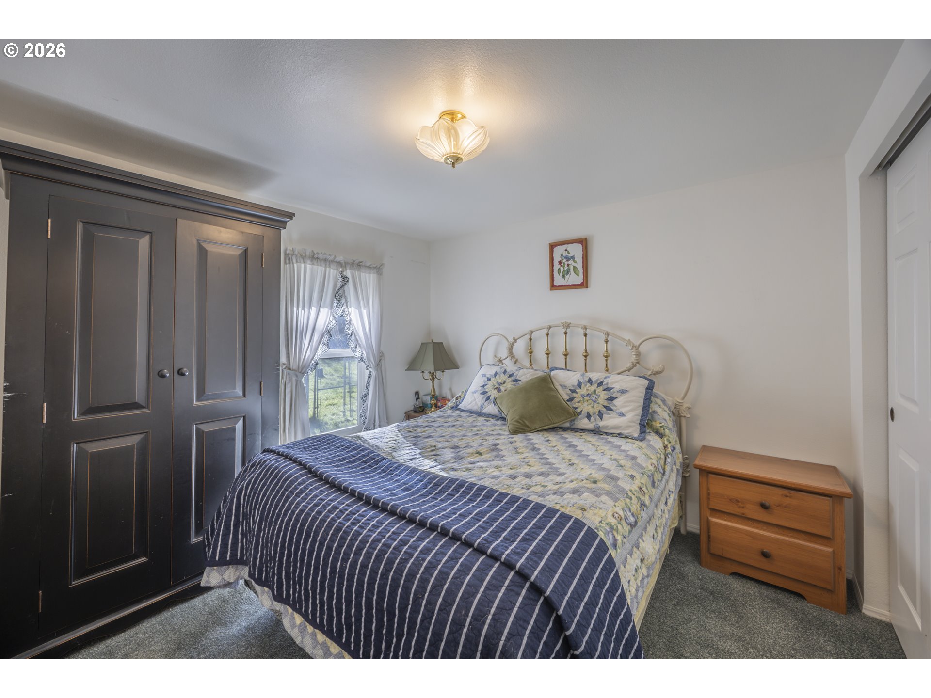 9580 North Fork Siuslaw Road Florence, OR 97439 - Photo 43 of 48 a bedroom with a bed and a lamp