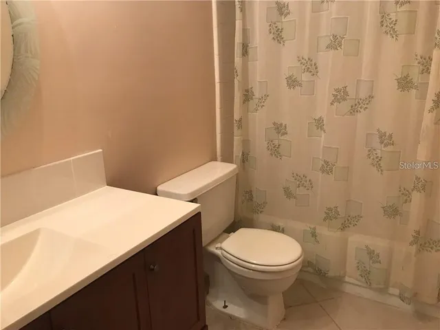 a white toilet sitting next to a shower curtain