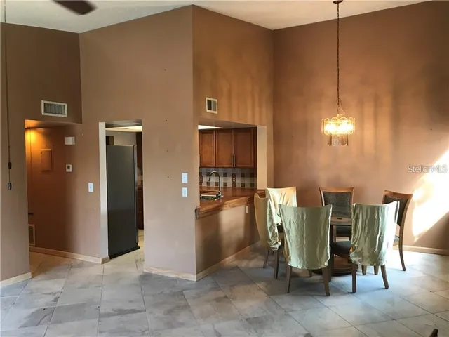 a view of a kitchen with refrigerator and cabinets