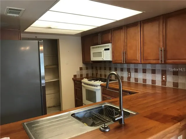 a room with wooden cabinets and stainless steel appliances