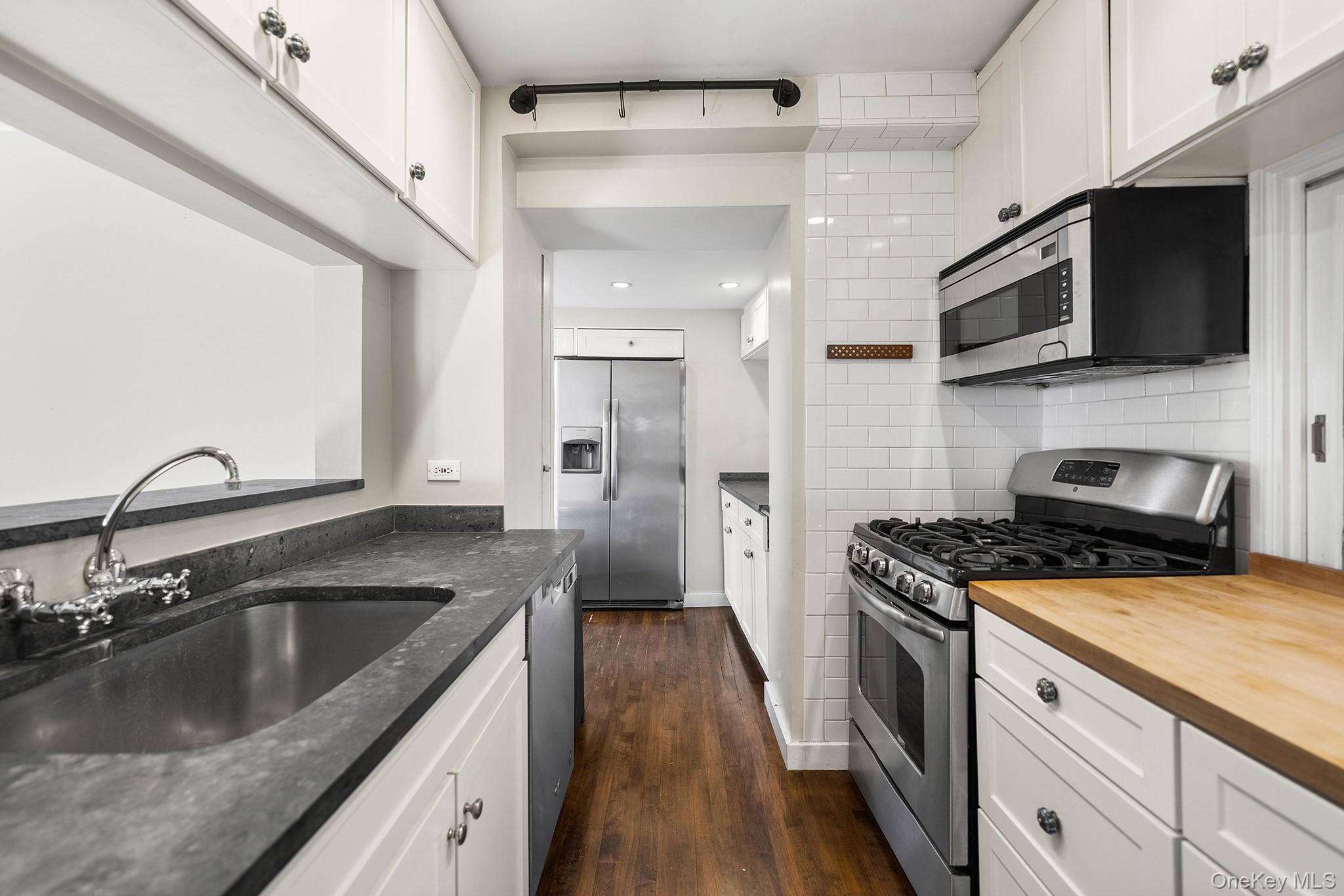 1007 Rte 9W Nyack, NY 10960 - Photo 16 of 45 a kitchen with stainless steel appliances granite countertop a sink a stove top oven a refrigerator with wooden floors and cabinets