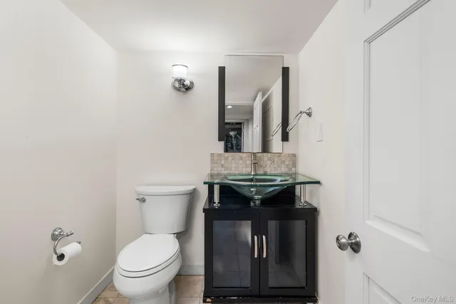 a bathroom with a granite countertop toilet a sink and mirror