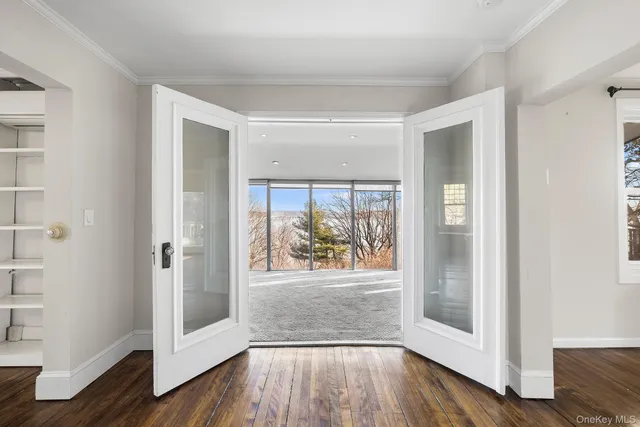 a view of a hallway with wooden floor and a window