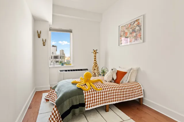 a bedroom with a bed and painting on the wall