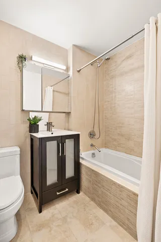 a bathroom with a granite countertop sink a toilet and bathtub