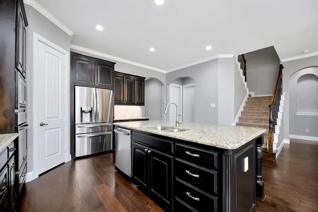 a view of kitchen island with a sink and refrigerator