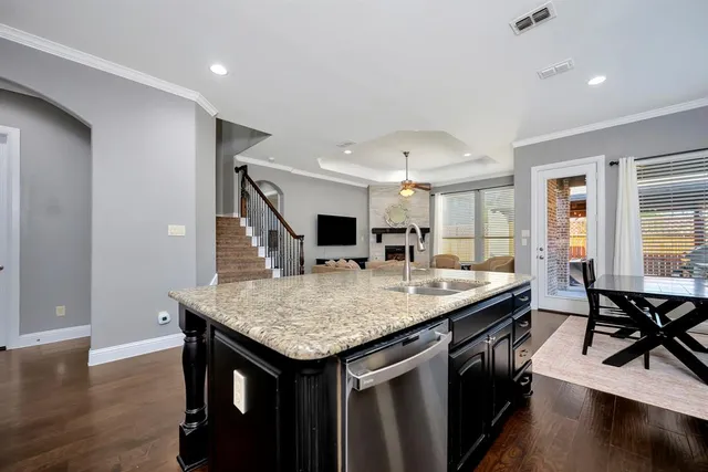 a kitchen with granite countertop stainless steel appliances and wooden floor