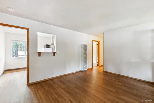 a view of a big room with wooden floor and windows