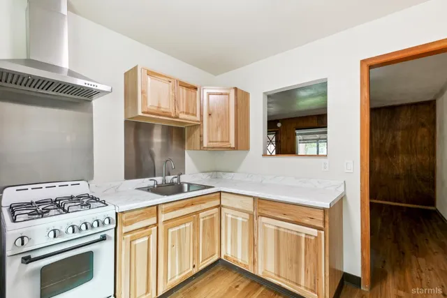 a kitchen with granite countertop cabinets stainless steel appliances and wooden floor
