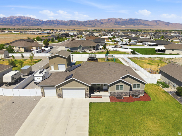 664 South Saddle Road Grantsville, UT 84029 - Photo 4 of 78 Single-story residence featuring a two-car garage, solar panels, and a concrete driveway