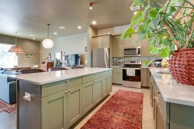 a kitchen with kitchen island granite countertop a stove and a sink