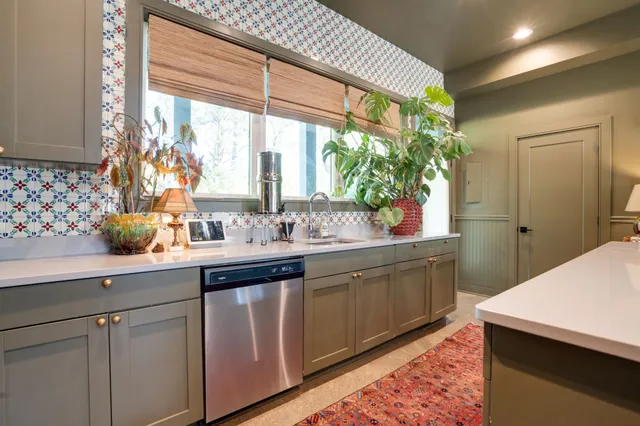 a kitchen with stainless steel appliances sink and wooden floor