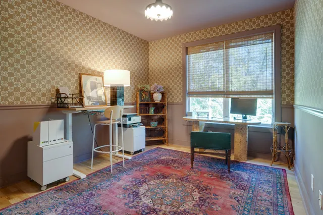 a view of a workspace with furniture and a window