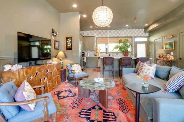 a living room with furniture chandelier and a large window