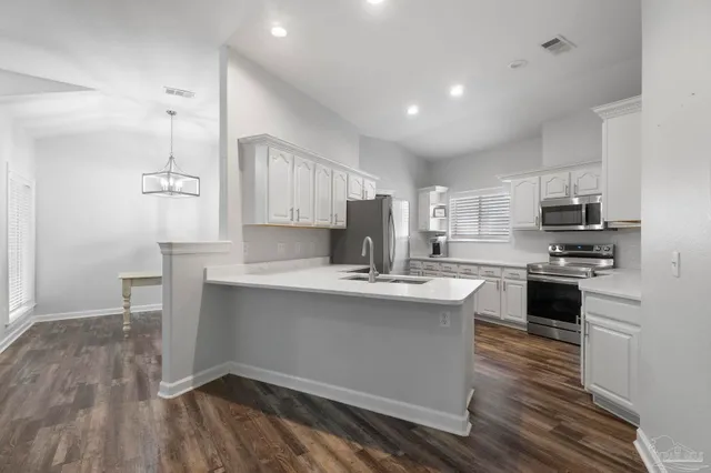 a kitchen with kitchen island a sink stainless steel appliances and cabinets