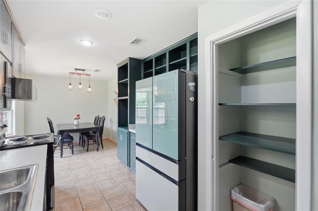 837 Springdale Road Bedford, TX 76021 - Photo 8 of 28 Kitchen and dining area featuring tile flooring, recessed lighting, built-in shelving, a kitchen sink with a stainless steel faucet, and a contemporary linear pendant light fixture